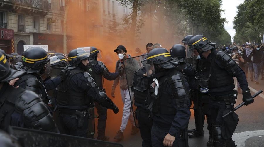 Protestors march waving French flags during a demonstration in Paris, France, Saturday, July 31, 2021. Demonstrators gathered in several cities in France on Saturday to protest against the COVID-19 pass, which grants vaccinated individuals greater ease of access to venues. (AP Photo/Adrienne Surprenant)