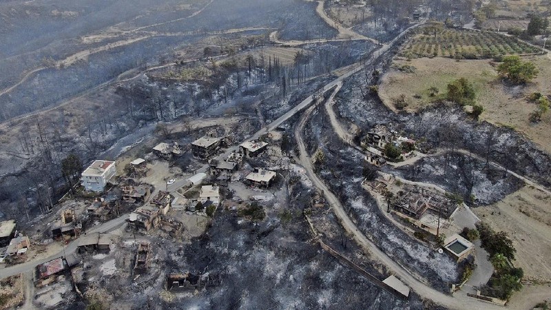 An aerial photo shows destroyed houses in a village as wildfires continue to rage the forests near the Mediterranean coastal town of Manavgat, Antalya, Turkey, Thursday, July 29, 2021. Authorities evacuated homes in southern Turkey as a wildfire fanned by strong winds raged through a forest area near the Mediterranean coastal town of Manavgat. District governor Mustafa Yigit said residents of four neighborhoods were moved out of the fire's path as firefighters worked to control the blaze that broke out Wednesday. It was not immediately clear what caused the fire but authorities said nearby tourist resorts were not affected. (Suat Metin/IHA via AP)