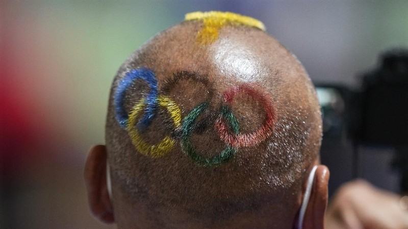 Mongolian coach Undralbat Lkhagva has the Olympic rings cut and dyed into his hair as he watches the women's 10-meter air pistol at the Asaka Shooting Range in the 2020 Summer Olympics, Sunday, July 25, 2021, in Tokyo, Japan. (AP Photo/Alex Brandon)