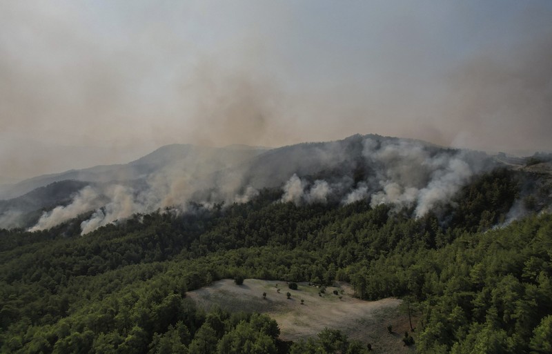 An aerial photo shows destroyed houses in a village as wildfires continue to rage the forests near the Mediterranean coastal town of Manavgat, Antalya, Turkey, Thursday, July 29, 2021. Authorities evacuated homes in southern Turkey as a wildfire fanned by strong winds raged through a forest area near the Mediterranean coastal town of Manavgat. District governor Mustafa Yigit said residents of four neighborhoods were moved out of the fire's path as firefighters worked to control the blaze that broke out Wednesday. It was not immediately clear what caused the fire but authorities said nearby tourist resorts were not affected. (Suat Metin/IHA via AP)