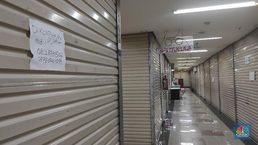 Pengunjung melintas di kios yang terpampang tulisan 