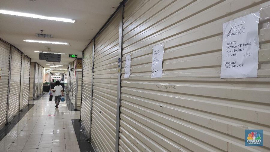 Pengunjung melintas di kios yang terpampang tulisan 