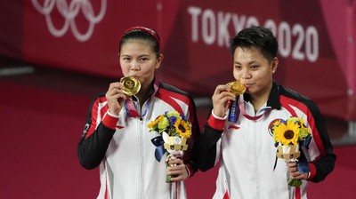 Tokyo Olympics Badminton Gold medalists Greysia Polii, left, and Apriyani Rahayu from Indonesia celebrate during the medals ceremony of the women's doubles gold medal match at the 2020 Summer Olympics, Monday, Aug. 2, 2021, in Tokyo, Japan. (AP Photo/Markus Schreiber)