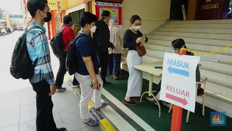 Petugas mengecek kartu vaksin pengunjung yang akan masuk kedalam mal ITC Fatmawati, Selasa (3/8/2021). Pengelola pusat perbelanjaan mendukung rencana masuk mal harus menunjukkan setifikat vaksin, hal ini dinilai dapat mempercepat program vaksinasi Covid-19 dan untuk mencapai kekebalan kelompok (herd immunity). (CNBC Indonesia/Tri Susilo)