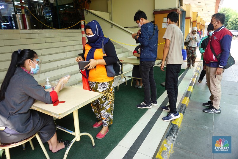 Petugas mengecek kartu vaksin pengunjung yang akan masuk kedalam mal ITC Fatmawati, Selasa (3/8/2021). Pengelola pusat perbelanjaan mendukung rencana masuk mal harus menunjukkan setifikat vaksin, hal ini dinilai dapat mempercepat program vaksinasi Covid-19 dan untuk mencapai kekebalan kelompok (herd immunity). (CNBC Indonesia/Tri Susilo) Petugas mengecek kartu vaksin pengunjung yang akan masuk kedalam mal ITC Fatmawati, Selasa (3/8/2021). Pengelola pusat perbelanjaan mendukung rencana masuk mal harus menunjukkan setifikat vaksin, hal ini dinilai dapat mempercepat program vaksinasi Covid-19 dan untuk mencapai kekebalan kelompok (herd immunity). (CNBC Indonesia/Tri Susilo)