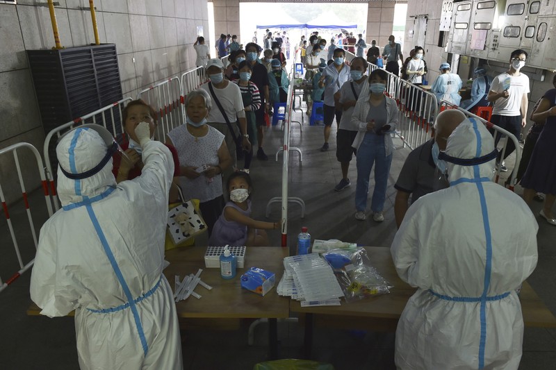 Virus Outbreak China Residents rush to stock up on necessities at a supermarket after authorities lockdown near residential blocks to prevent the spread of the COVID-19 in Wuhan city in central China's Hubei province Monday, Aug. 2, 2021. Chinese authorities announced Tuesday the mass testing of Wuhan as an unusually wide series of COVID-19 outbreaks reached the city where the disease was first detected in late 2019. (Chinatopix via AP)