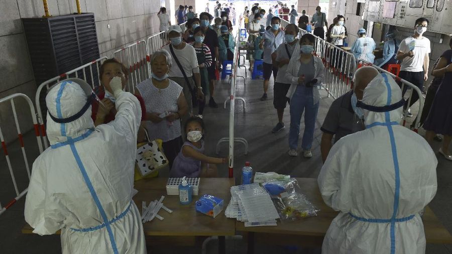 Medical workers takes throat swab samples in new round of COVID-19 testing in Nanjing city in eastern China's Jiangsu province Monday, Aug. 2, 2021 The current coronavirus outbreaks in China, while still in the hundreds of cases in total, have spread much more widely than previous ones, reaching multiple provinces and cities including the capital, Beijing. Many of the cases have been identified as the highly contagious delta variant that is driving a resurgence in many countries. (Chinatopix via AP)