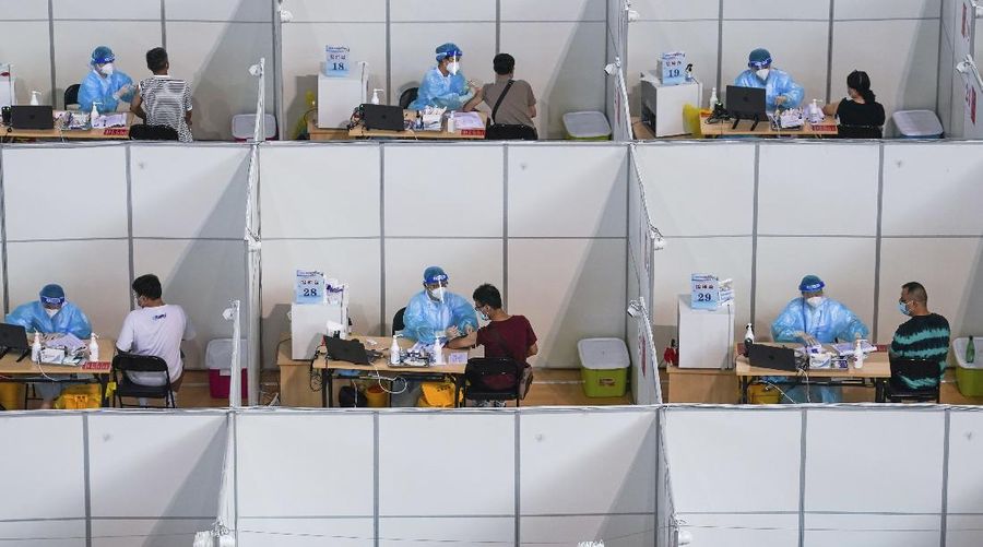 In this photo released by China's Xinhua News Agency, people get COVID-19 vaccinations at a vaccination site at a sports arena in Nanjing in eastern China's Jiangsu Province, Monday, Aug. 2, 2021. Chinese authorities announced Tuesday mass coronavirus testing in Wuhan as an unusually wide series of COVID-19 outbreaks reached the city where the disease was first detected in late 2019. Most of the local cases are still in Jiangsu province, where an outbreak started at the airport in Nanjing, the provincial capital, and has spread to the city of Yangzhou. (Li Bo/Xinhua via AP)