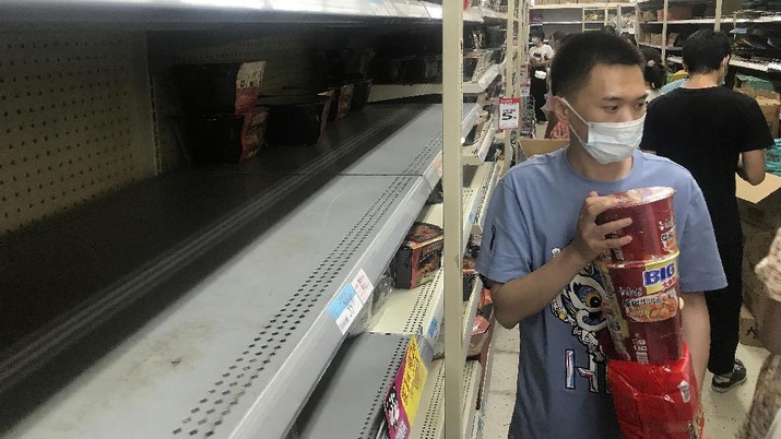 Shelves are empty as residents rush to stock up on necessities at a supermarket after authorities lockdown near residential blocks to prevent the spread of the COVID-19 in Wuhan city in central China's Hubei province Monday, Aug. 2, 2021. Chinese authorities announced Tuesday the mass testing of Wuhan as an unusually wide series of COVID-19 outbreaks reached the city where the disease was first detected in late 2019. (Chinatopix via AP)