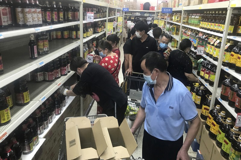 Virus Outbreak China Residents rush to stock up on necessities at a supermarket after authorities lockdown near residential blocks to prevent the spread of the COVID-19 in Wuhan city in central China's Hubei province Monday, Aug. 2, 2021. Chinese authorities announced Tuesday the mass testing of Wuhan as an unusually wide series of COVID-19 outbreaks reached the city where the disease was first detected in late 2019. (Chinatopix via AP)