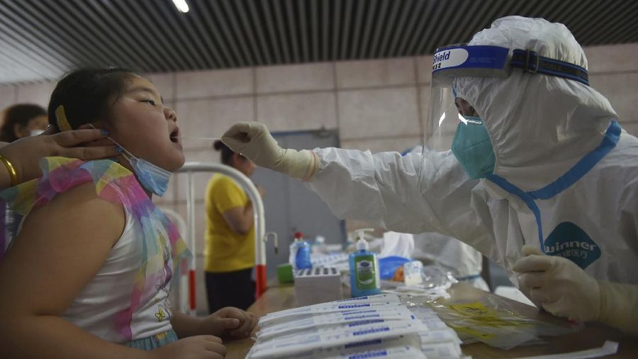 A nurse takes throat swab samples in new round of COVID-19 testing in Nanjing city in eastern China's Jiangsu province Monday, Aug. 2, 2021. The current coronavirus outbreaks in China, while still in the hundreds of cases in total, have spread much more widely than previous ones, reaching multiple provinces and cities including the capital, Beijing. Many of the cases have been identified as the highly contagious delta variant that is driving a resurgence in many countries. (Chinatopix via AP)