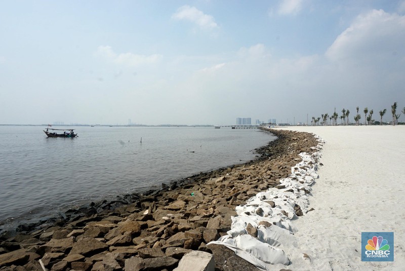 Suasana pantai pasir putih di Kawasan PIK 2, Dadap, Tangerang, Banten, Rabu (4/8/2021). Pantai Pasir Putih di kawasan Pantai Indah Kapuk tengah populer di kalangan traveler. Semenjak dibuka tahun 2020 lalu, tak sedikit traveler yang singgah ke Pantai Pasir Putih kala bertandang ke PIK. Di tengah kondisi pandemi, destinasi outdoor ini memang jadi primadona. Kini sejak diberlakukan PPKM darurat level 4 terlihat kawasan pasir putih sepi pengunjung. Hanya beberapa perahu nelayan yang sedang mencari  ikan di perairan laut pasir putih. Apabila PIK pertama berada di Provinsi DKI Jakarta, maka Pantai Pasir Putih di PIK2 masuk ke Provinsi Banten. (CNBC Indonesia/ Muhammad Sabki)