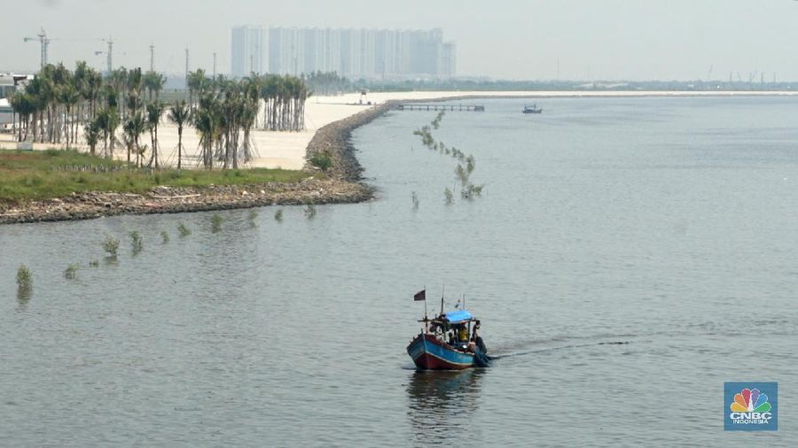 Suasana pantai pasir putih di Kawasan PIK 2, Dadap, Tangerang, Banten, Rabu (4/8/2021). Pantai Pasir Putih di kawasan Pantai Indah Kapuk tengah populer di kalangan traveler. Semenjak dibuka tahun 2020 lalu, tak sedikit traveler yang singgah ke Pantai Pasir Putih kala bertandang ke PIK. Di tengah kondisi pandemi, destinasi outdoor ini memang jadi primadona. Kini sejak diberlakukan PPKM darurat level 4 terlihat kawasan pasir putih sepi pengunjung. Hanya beberapa perahu nelayan yang sedang mencari ikan di perairan laut pasir putih. Apabila PIK pertama berada di Provinsi DKI Jakarta, maka Pantai Pasir Putih di PIK2 masuk ke Provinsi Banten. (CNBC Indonesia/ Muhammad Sabki)