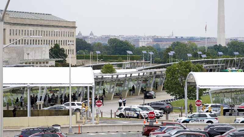 A police officer looks at a vehicle outside the Pentagon, Tuesday, Aug. 3, 2021 in Washington. Gunshots were fired Tuesday morning near the entrance of the Pentagon, resulting in multiple injuries. The facility, the headquarters of the U.S. military, was placed on lockdown. The incident occurred on a Metro bus platform that is part of the Pentagon Transit Center, the Pentagon Protection Force Protection Agency tweeted. (AP Photo/Andrew Harnik)