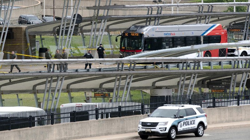 A police officer looks at a vehicle outside the Pentagon, Tuesday, Aug. 3, 2021 in Washington. Gunshots were fired Tuesday morning near the entrance of the Pentagon, resulting in multiple injuries. The facility, the headquarters of the U.S. military, was placed on lockdown. The incident occurred on a Metro bus platform that is part of the Pentagon Transit Center, the Pentagon Protection Force Protection Agency tweeted. (AP Photo/Andrew Harnik)
