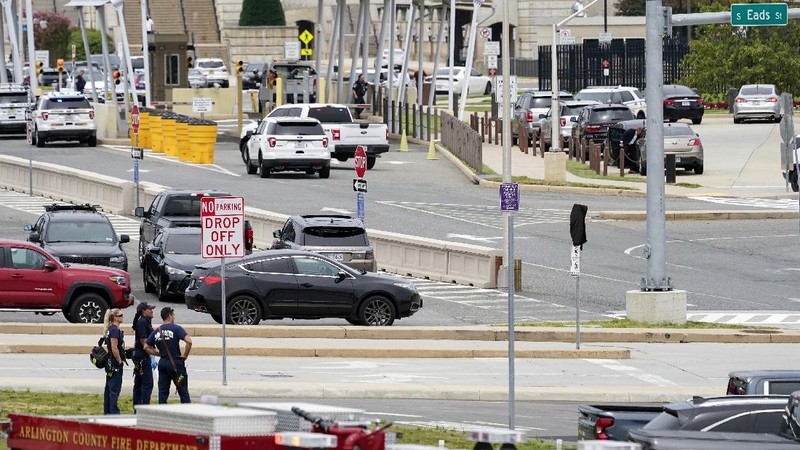 A police officer looks at a vehicle outside the Pentagon, Tuesday, Aug. 3, 2021 in Washington. Gunshots were fired Tuesday morning near the entrance of the Pentagon, resulting in multiple injuries. The facility, the headquarters of the U.S. military, was placed on lockdown. The incident occurred on a Metro bus platform that is part of the Pentagon Transit Center, the Pentagon Protection Force Protection Agency tweeted. (AP Photo/Andrew Harnik)