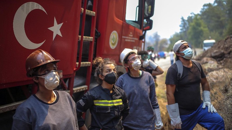 Turkish volunteers head to fight wildfires in Turgut village, near tourist resort of Marmaris, Mugla, Turkey, Wednesday, Aug. 4, 2021. As Turkish fire crews pressed ahead Tuesday with their weeklong battle against blazes tearing through forests and villages on the country's southern coast, President Recep Tayyip Erdogan's government faced increased criticism over its apparent poor response and inadequate preparedness for large-scale wildfires.(AP Photo/Emre Tazegul)