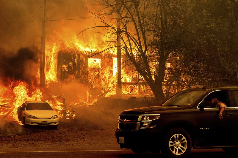 Flames from the Dixie Fire consume a pickup truck on Highway 89 south of Greenville on Thursday, Aug. 5, 2021, in Plumas County, Calif. (AP Photo/Noah Berger)