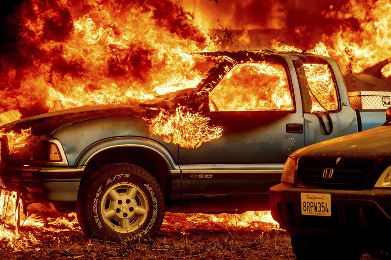 Flames from the Dixie Fire consume a pickup truck on Highway 89 south of Greenville on Thursday, Aug. 5, 2021, in Plumas County, Calif. (AP Photo/Noah Berger)