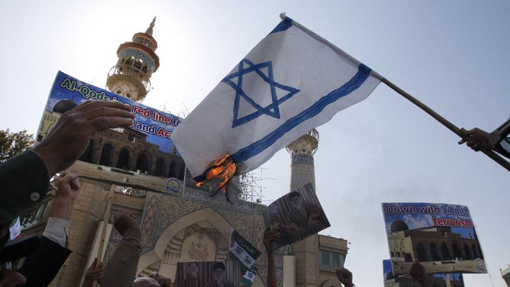 Iranian demonstrators symbolically burn an Israeli flag, during an anti-Israel demonstration, after their Friday prayers at the Felestin (Palestine) Sq. in Tehran, Iran, Friday, Oct. 9, 2009. (AP Photo/Vahid Salemi)