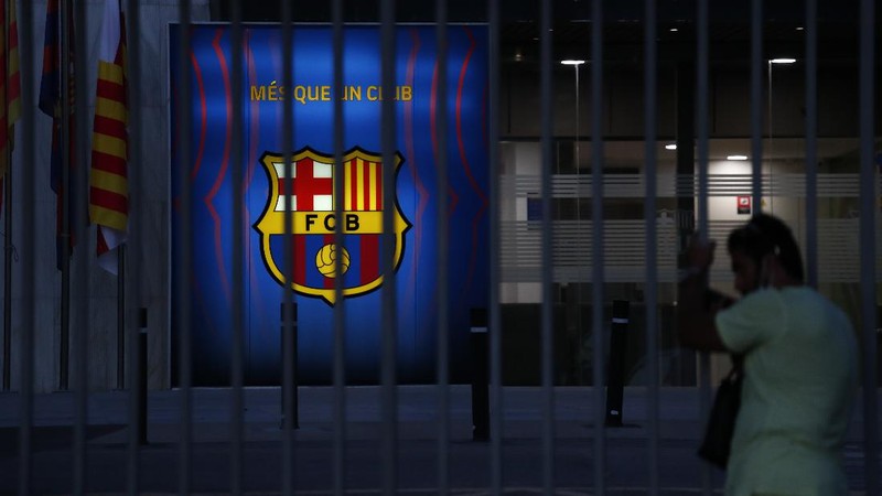 A fan wearing the number 10 Lionel Messi replica shirt sits outside the club offices with others in Barcelona, Spain, Thursday, Aug. 5, 2021. Barcelona announced Thursday that Messi will not stay with the club, saying that the Spanish league's financial regulations made it impossible to sign the Argentina star to a new contract. (AP Photo/Joan Monfort)