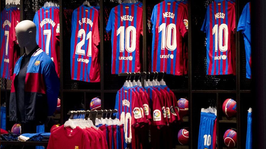 A fan wearing the number 10 Lionel Messi replica shirt sits outside the club offices with others in Barcelona, Spain, Thursday, Aug. 5, 2021. Barcelona announced Thursday that Messi will not stay with the club, saying that the Spanish league's financial regulations made it impossible to sign the Argentina star to a new contract. (AP Photo/Joan Monfort)
