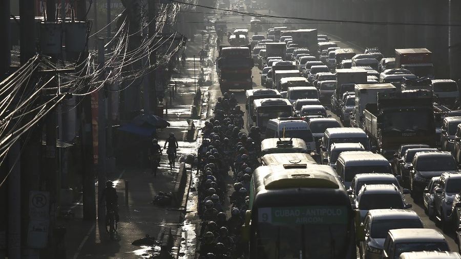 Traffic builds up near a checkpoint during a stricter lockdown as a precaution against the spread of the new coronavirus disease at the outskirts of Marikina City, Philippines on Friday, August 6, 2021. Thousands of people jammed coronavirus vaccination centers in the Philippine capital, defying social distancing restrictions, after false news spread that unvaccinated residents would be deprived of cash aid or barred from leaving home during a two-week lockdown that started Friday. (AP Photo/Basilio Sepe)