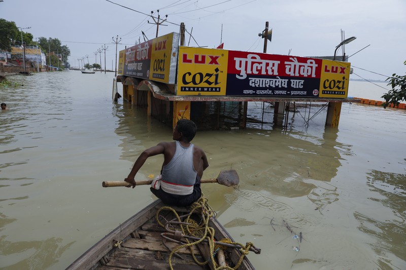 A man rows his boat through a flooded river Ganges following heavy monsoon rains in Prayagraj, India, Saturday, Aug. 7, 2021. (AP Photo/Rajesh Kumar Singh)