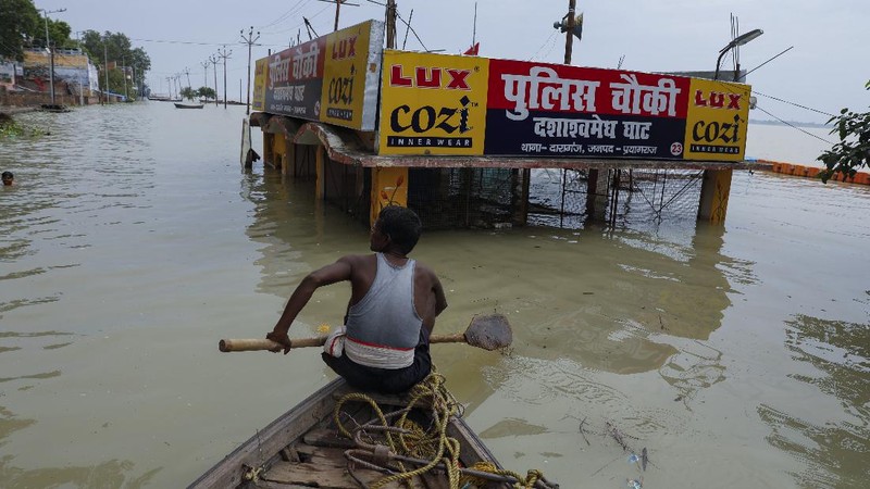 A man rows his boat through a flooded river Ganges following heavy monsoon rains in Prayagraj, India, Saturday, Aug. 7, 2021. (AP Photo/Rajesh Kumar Singh)