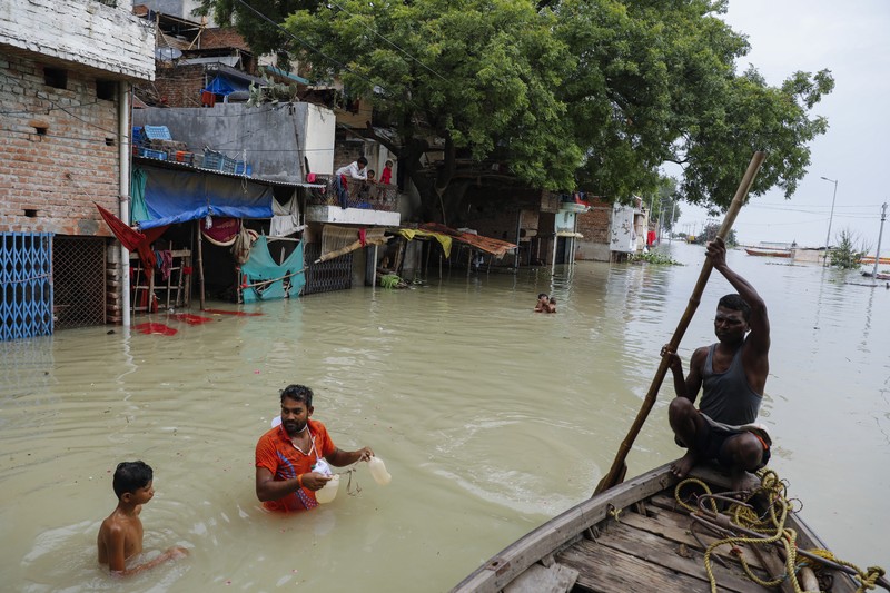 A man rows his boat through a flooded river Ganges following heavy monsoon rains in Prayagraj, India, Saturday, Aug. 7, 2021. (AP Photo/Rajesh Kumar Singh)