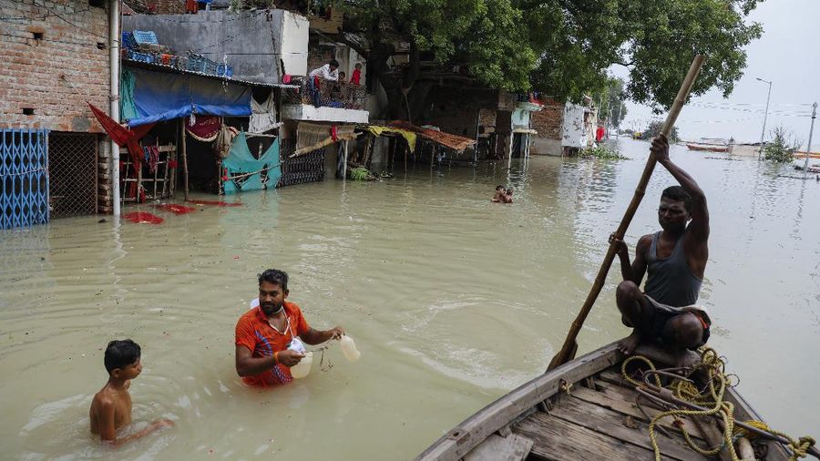 A man rows his boat through a flooded river Ganges following heavy monsoon rains in Prayagraj, India, Saturday, Aug. 7, 2021. (AP Photo/Rajesh Kumar Singh)