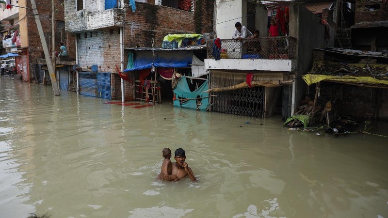 A man rows his boat through a flooded river Ganges following heavy monsoon rains in Prayagraj, India, Saturday, Aug. 7, 2021. (AP Photo/Rajesh Kumar Singh)