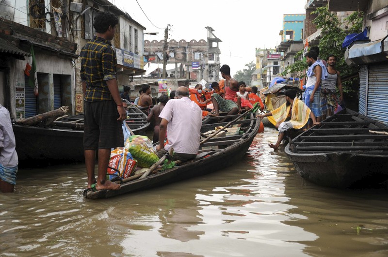 Banjir di India A man rows his boat through a flooded river Ganges following heavy monsoon rains in Prayagraj, India, Saturday, Aug. 7, 2021. (AP Photo/Rajesh Kumar Singh)