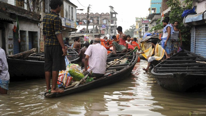 A man rows his boat through a flooded river Ganges following heavy monsoon rains in Prayagraj, India, Saturday, Aug. 7, 2021. (AP Photo/Rajesh Kumar Singh)