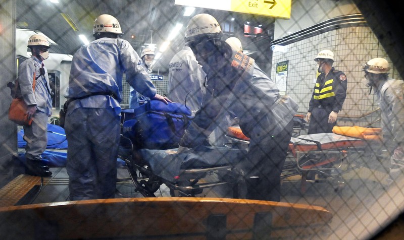 Penusukan di Tokyo Jepang Rescuers carry an injured passenger on stretcher at Soshigaya Okura Station after stabbing on a commuter train, in Tokyo Friday night, Aug. 6, 2021. A man with a knife attacked 10 passengers on a commuter train in Tokyo on Friday and was arrested by police after fleeing, fire department officials and news reports said. (Kyodo News via AP)