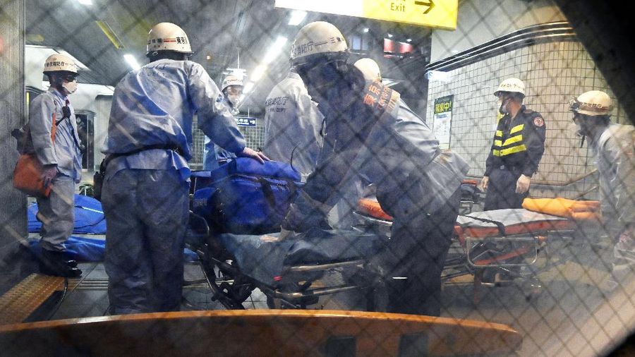 Rescuers papare stretchers at Soshigaya Okura Station after stabbing on a commuter train, in Tokyo Friday, Aug. 6, 2021. A man with a knife stabbed passengers on a commuter train Friday and was arrested by police after fleeing, fire department officials and news reports said. (Kyodo News via AP)