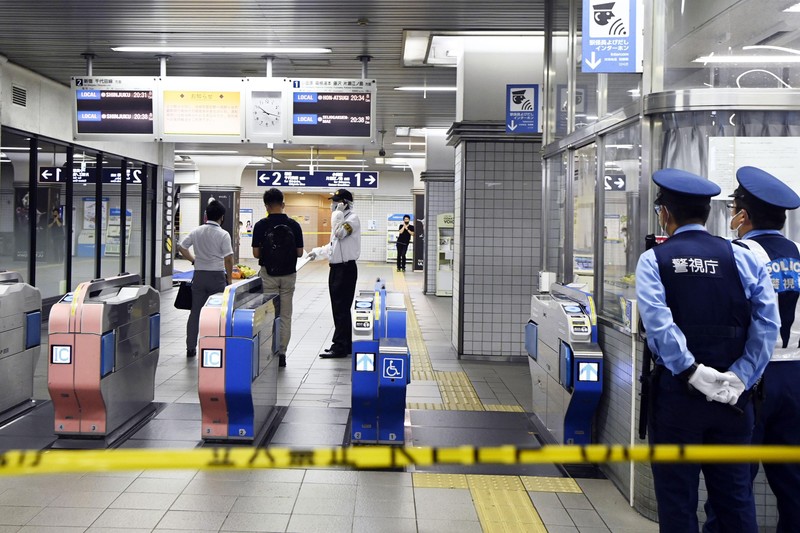 Penusukan di Tokyo Jepang Rescuers carry an injured passenger on stretcher at Soshigaya Okura Station after stabbing on a commuter train, in Tokyo Friday night, Aug. 6, 2021. A man with a knife attacked 10 passengers on a commuter train in Tokyo on Friday and was arrested by police after fleeing, fire department officials and news reports said. (Kyodo News via AP)