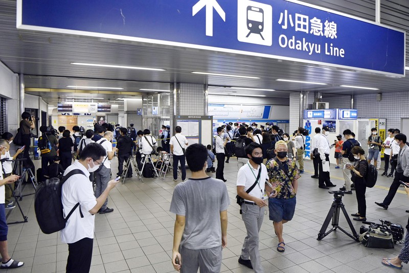 Penusukan di Tokyo Jepang Rescuers carry an injured passenger on stretcher at Soshigaya Okura Station after stabbing on a commuter train, in Tokyo Friday night, Aug. 6, 2021. A man with a knife attacked 10 passengers on a commuter train in Tokyo on Friday and was arrested by police after fleeing, fire department officials and news reports said. (Kyodo News via AP)
