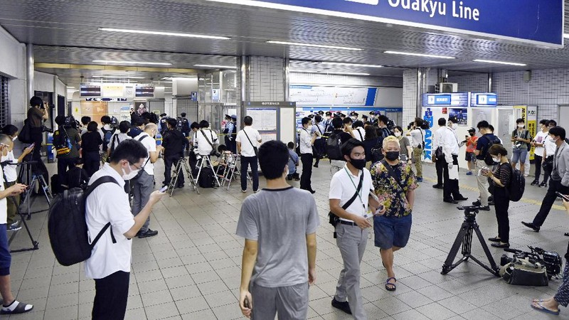 Rescuers carry an injured passenger on  stretcher at Soshigaya Okura Station after stabbing on a commuter train, in Tokyo Friday night, Aug. 6, 2021. A man with a knife attacked 10 passengers on a commuter train in Tokyo on Friday and was arrested by police after fleeing, fire department officials and news reports said. (Kyodo News via AP)