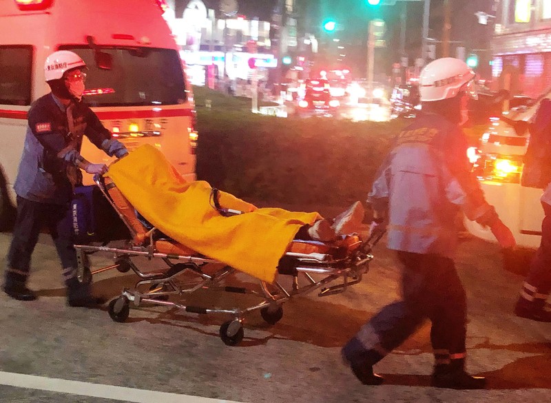 Penusukan di Tokyo Jepang Rescuers carry an injured passenger on stretcher at Soshigaya Okura Station after stabbing on a commuter train, in Tokyo Friday night, Aug. 6, 2021. A man with a knife attacked 10 passengers on a commuter train in Tokyo on Friday and was arrested by police after fleeing, fire department officials and news reports said. (Kyodo News via AP)