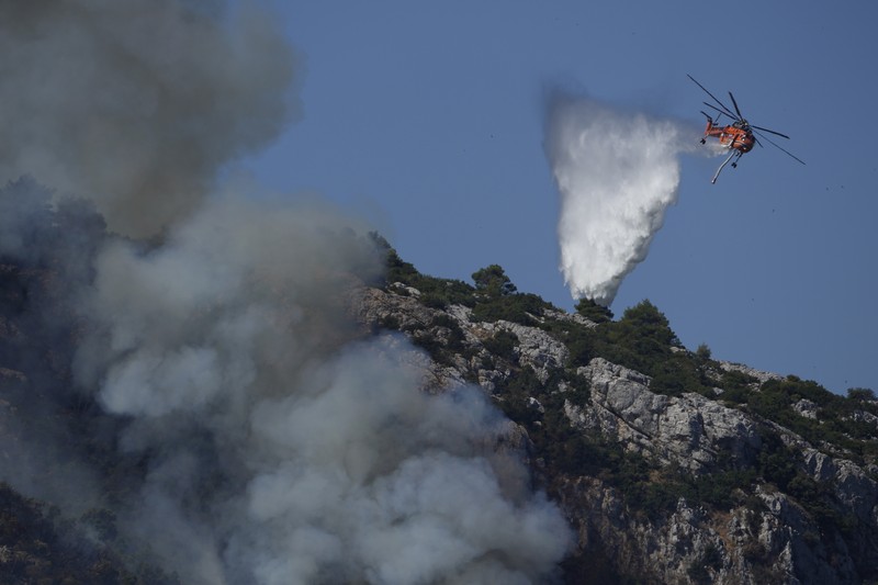 Flames burn on the mountain near Limni village on the island of Evia, about 160 kilometers (100 miles) north of Athens, Greece, Tuesday, Aug. 3, 2021. Greece Tuesday grappled with the worst heatwave in decades that strained the national power supply and fueled wildfires near Athens and elsewhere in southern Greece. As the heat wave scorching the eastern Mediterranean intensified, temperatures reached 42 degrees Celsius (107.6 Fahrenheit) in parts of the Greek capital. (AP Photo/Michael Pappas)