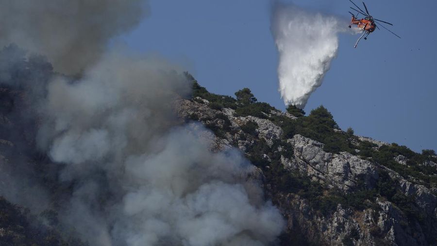 Flames burn on the mountain near Limni village on the island of Evia, about 160 kilometers (100 miles) north of Athens, Greece, Tuesday, Aug. 3, 2021. Greece Tuesday grappled with the worst heatwave in decades that strained the national power supply and fueled wildfires near Athens and elsewhere in southern Greece. As the heat wave scorching the eastern Mediterranean intensified, temperatures reached 42 degrees Celsius (107.6 Fahrenheit) in parts of the Greek capital. (AP Photo/Michael Pappas)