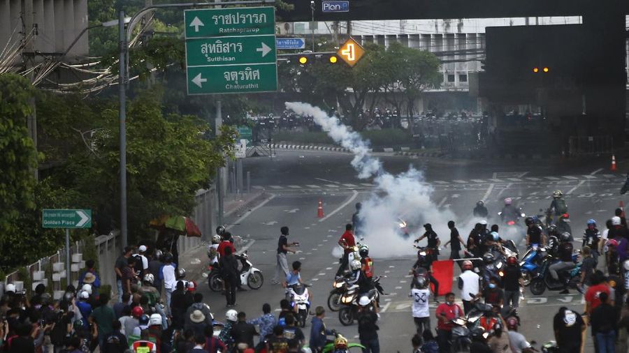 Riot police launch tear gas to anti-government protesters during a protest in Bangkok, Thailand, Saturday, Aug. 7, 2021. Protesters demanded the resignation of Prime Minister Prayuth Chan-ocha and for part of the budget for the monarchy and the military to be redirected into the fight against the coronavirus. Many people blame Prayuth and his administration for failing to develop an adequate vaccination policy. (AP Photo/Anuthep Cheysakron)