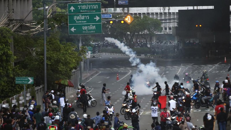 Riot police launch tear gas to anti-government protesters during a protest in Bangkok, Thailand, Saturday, Aug. 7, 2021. Protesters demanded the resignation of Prime Minister Prayuth Chan-ocha and for part of the budget for the monarchy and the military to be redirected into the fight against the coronavirus. Many people blame Prayuth and his administration for failing to develop an adequate vaccination policy. (AP Photo/Anuthep Cheysakron)