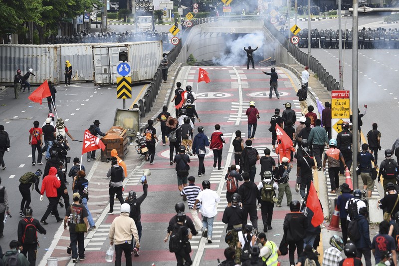 Riot police launch tear gas to anti-government protesters during a protest in Bangkok, Thailand, Saturday, Aug. 7, 2021. Protesters demanded the resignation of Prime Minister Prayuth Chan-ocha and for part of the budget for the monarchy and the military to be redirected into the fight against the coronavirus. Many people blame Prayuth and his administration for failing to develop an adequate vaccination policy. (AP Photo/Anuthep Cheysakron)