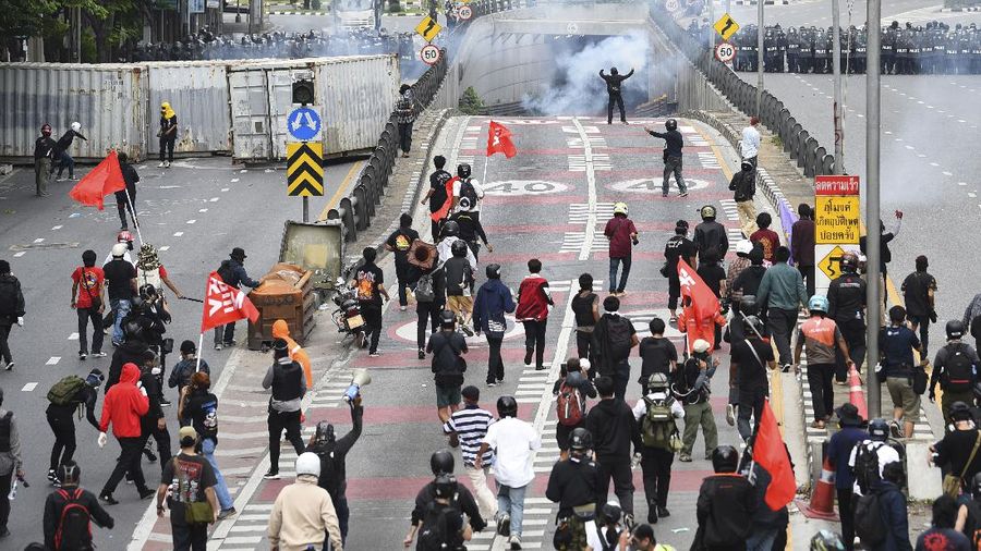 Riot police launch tear gas to anti-government protesters during a protest in Bangkok, Thailand, Saturday, Aug. 7, 2021. Protesters demanded the resignation of Prime Minister Prayuth Chan-ocha and for part of the budget for the monarchy and the military to be redirected into the fight against the coronavirus. Many people blame Prayuth and his administration for failing to develop an adequate vaccination policy. (AP Photo/Anuthep Cheysakron)