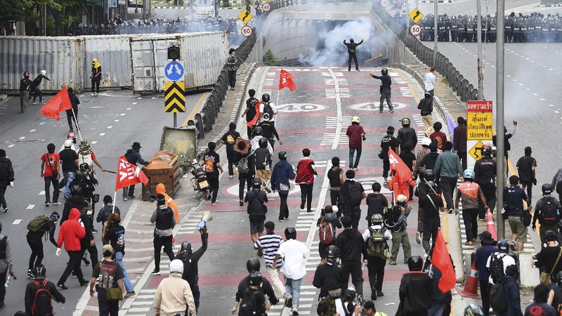 Riot police launch tear gas to anti-government protesters during a protest in Bangkok, Thailand, Saturday, Aug. 7, 2021. Protesters demanded the resignation of Prime Minister Prayuth Chan-ocha and for part of the budget for the monarchy and the military to be redirected into the fight against the coronavirus. Many people blame Prayuth and his administration for failing to develop an adequate vaccination policy. (AP Photo/Anuthep Cheysakron)