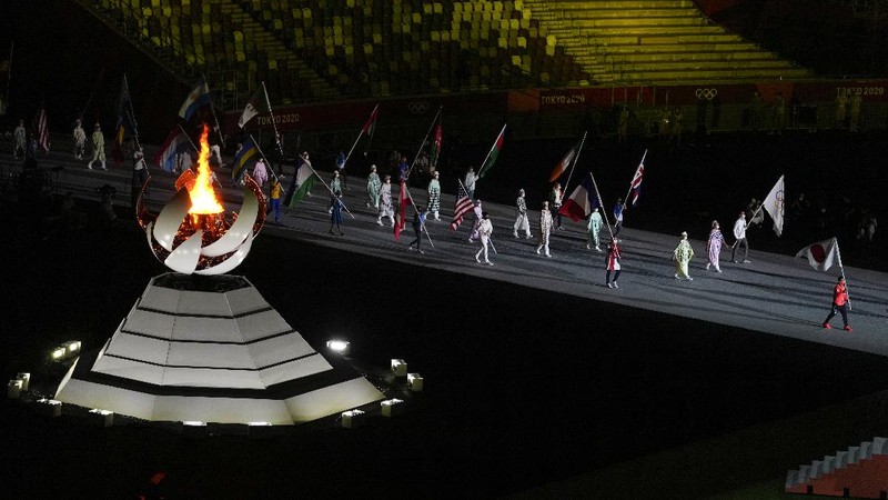 Flags are carried in during the closing ceremony in the Olympic Stadium at the 2020 Summer Olympics, Sunday, Aug. 8, 2021, in Tokyo, Japan. (AP Photo/Charlie Riedel)