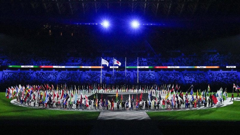 Flags are carried in during the closing ceremony in the Olympic Stadium at the 2020 Summer Olympics, Sunday, Aug. 8, 2021, in Tokyo, Japan. (AP Photo/Charlie Riedel)