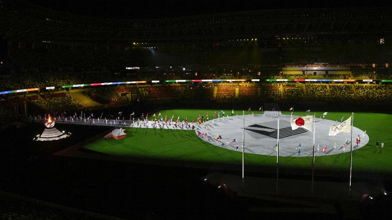 Flags are carried in during the closing ceremony in the Olympic Stadium at the 2020 Summer Olympics, Sunday, Aug. 8, 2021, in Tokyo, Japan. (AP Photo/Charlie Riedel)